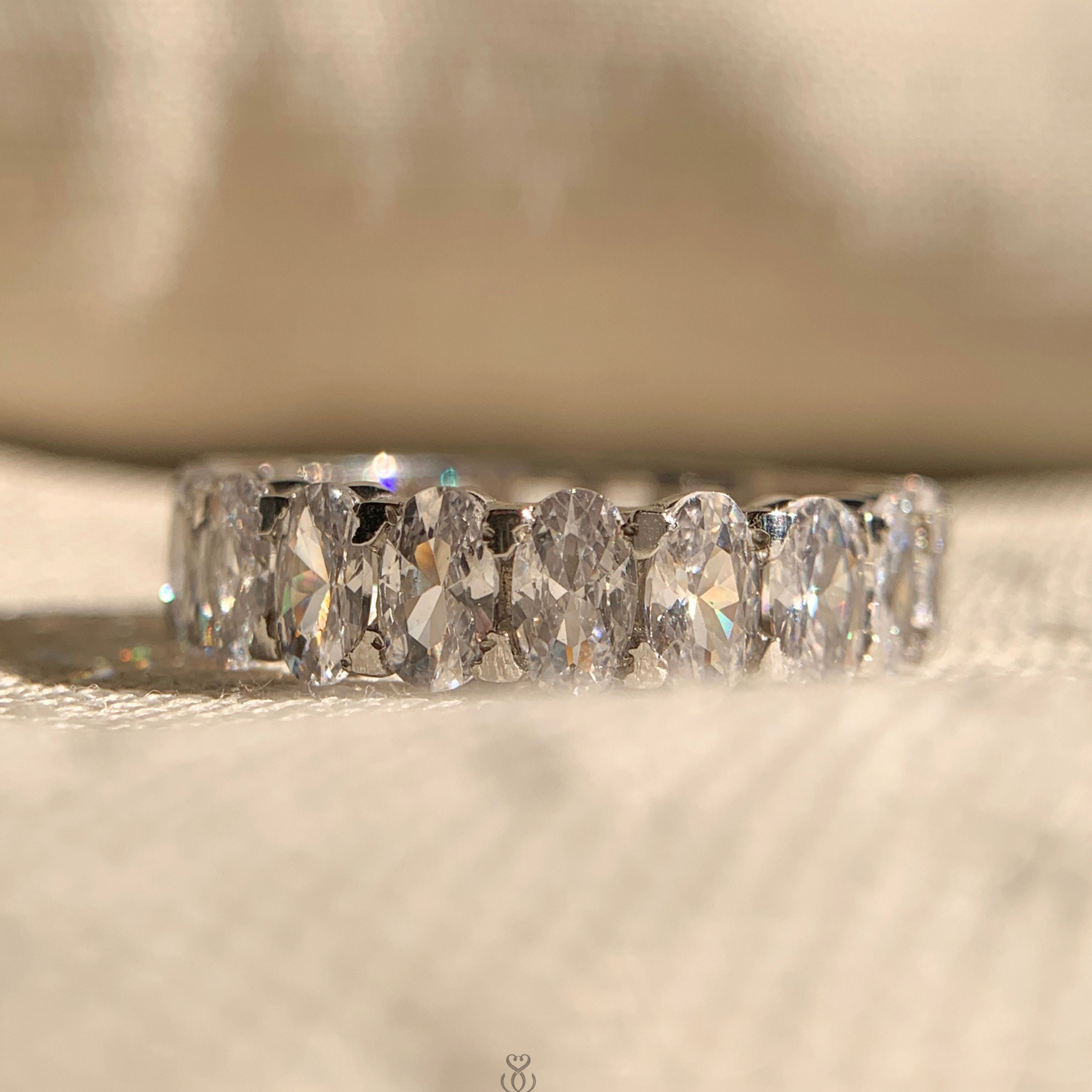 Half oval cut half emerald cut moissanite eternity band in sleek white gold